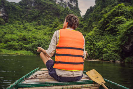 Man tourist in Trang An Scenic Landscape Complex in Ninh Binh Province, Vietnam A UNESCO World...