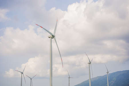 Wind power plant. green meadow with Wind turbines generating electricityの写真素材
