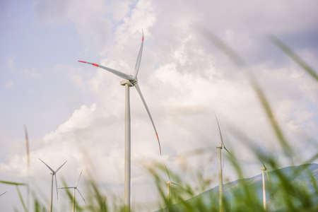 Wind power plant. green meadow with Wind turbines generating electricityの写真素材