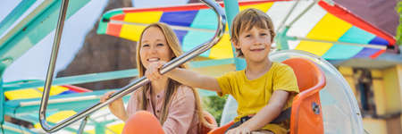happy smiling son and his mother spending fun time together at amusement park BANNER, LONG FORMATの写真素材