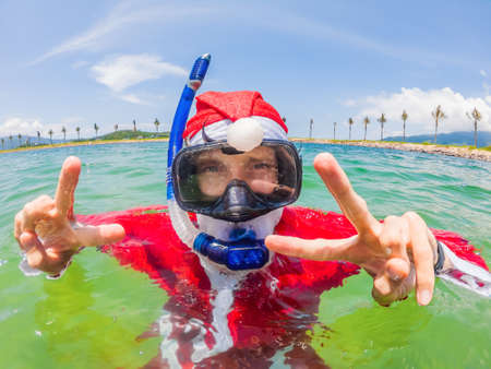 Santa claus is snorkeling underwater - christmas or happy new year concept. Christmas in the tropics after quarantine was liftedの写真素材