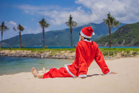 Santa Claus relaxing on sea beach - christmas or happy new year concept. Christmas in the tropics after quarantine was lifted Coronovirus COVID 19 conceptの写真素材