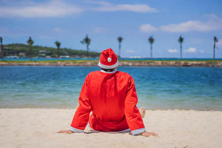 Santa Claus relaxing on sea beach - christmas or happy new year concept. Christmas in the tropics after quarantine was liftedの写真素材
