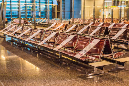 31.05.2021, Doha, Qatar: Socia distancing sign at airport seat, new normal concept. Deserted airport departure lounge in Qatar, UAEのeditorial素材