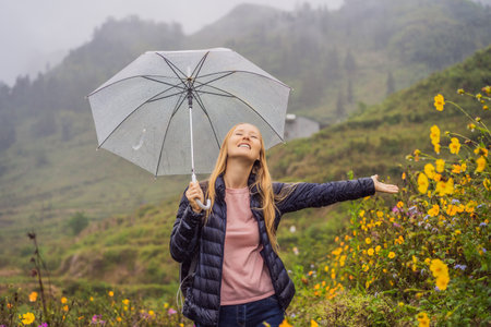 Woman tourist with umbrella in Sapa in the fog, Northwest Vietnam. Vietnam travel concept.