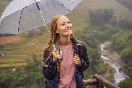Woman tourist with umbrella in Sapa in the fog, Northwest Vietnam. Vietnam travel concept. Vietnam opens to tourism after quarantine Coronovirus COVID 19の写真素材