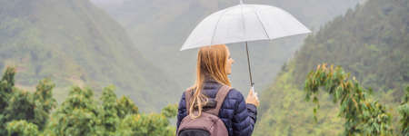 BANNER, LONG FORMAT Woman tourist with umbrella in Sapa in the fog, Northwest Vietnam.の写真素材