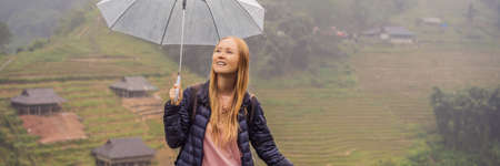 BANNER, LONG FORMAT Woman tourist with umbrella in Sapa in the fog, Northwest Vietnam.の写真素材