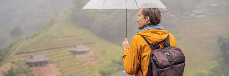 Man tourist with umbrella in Sapa in the fog, Northwest Vietnam. Vietnam travel concept.の写真素材