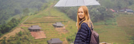 BANNER, LONG FORMAT Woman tourist with umbrella in Sapa in the fog, Northwest Vietnam.の写真素材