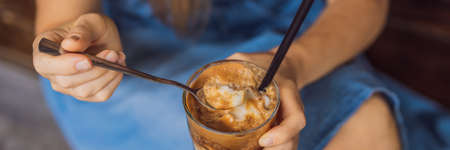 Happy beautiful girl sitting on stairs in park and drinking ice coffee BANNER, LONG FORMATの写真素材