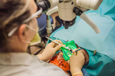 Dental treatment with a microscope. Man having teeth examined at dentists. Appointment at the...