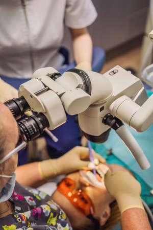 Dental treatment with a microscope. Woman having teeth examined at dentists. Appointment at the...