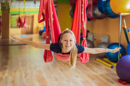 Young beautiful woman practicing aerial yoga in gym. Lifestyleの写真素材
