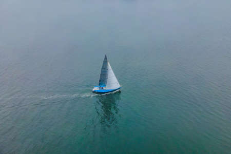 Aerial birds eye view photo taken by drone of sailboat in turquoise sea water