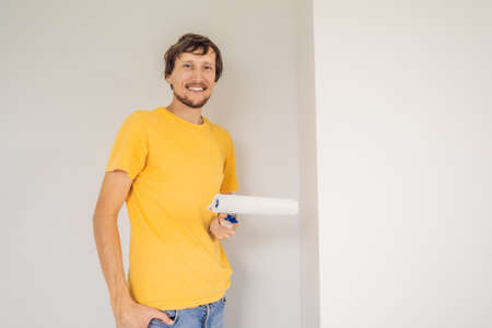 One male house painter worker painting and priming wall with painting roller. DIYの写真素材