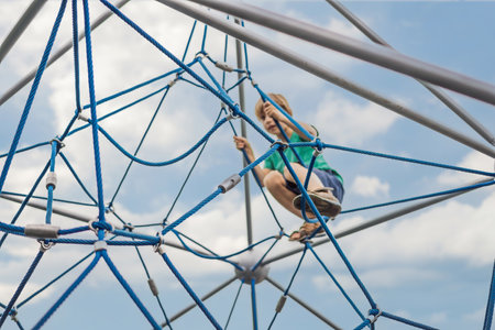 Young boy on climbing rope in playgroundの写真素材