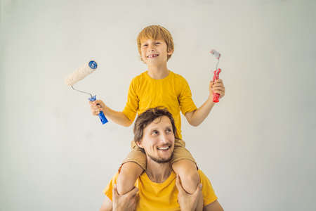 Father and son painting a wall in their home do it in the course of moving inの写真素材