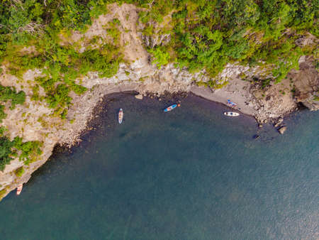 Young women Having Fun Stand Up Paddling in the sea. SUP. Red hair girl Training on Paddle Board near the rocksの写真素材
