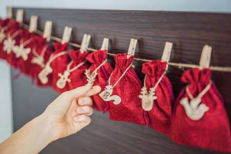 Woman making Christmas advent calendar. Pouches on a ropeの写真素材