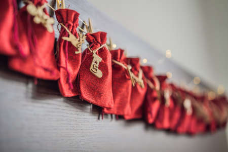 Advent calendar red bags on a rope hang on a childs bedの写真素材