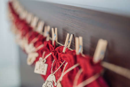 Advent calendar red bags on a rope hang on a childs bedの写真素材