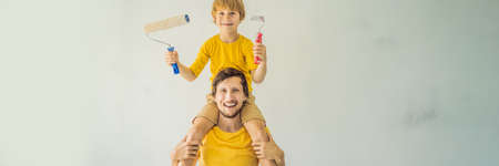 Father and son painting a wall in their home do it in the course of moving inの写真素材