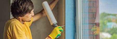Builder or handyman is engaged in the repair or installation of windowsの写真素材