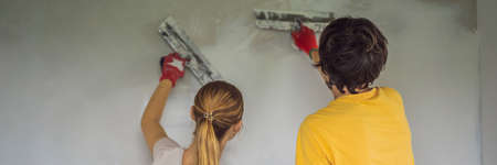 A man and a woman are plastering the walls of the house. DIY home renovationの写真素材