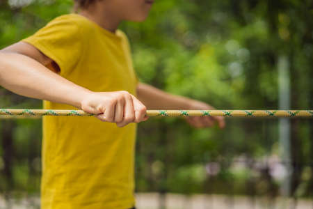 Little boy in a rope park. Active physical recreation of the child in the fresh air in the park. Training for childrenの写真素材