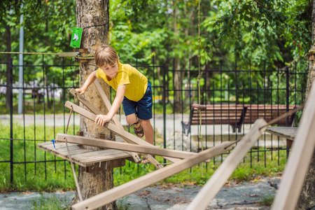 Little boy in a rope park. Active physical recreation of the child in the fresh air in the park. Training for childrenの写真素材