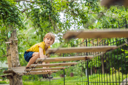 Little boy in a rope park. Active physical recreation of the child in the fresh air in the park....