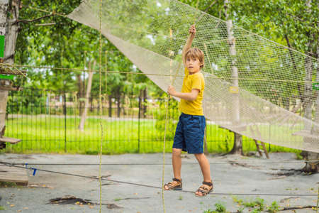 Little boy in a rope park. Active physical recreation of the child in the fresh air in the park. Training for childrenの写真素材
