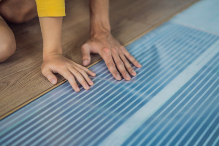 Wooden floor, laminate on a warm film floor. Comfort in home. Warm floor concept. Heating in the house and apartmentの写真素材