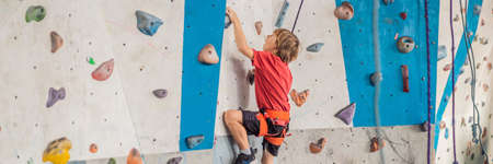 Boy at the climbing wall without a helmet, danger at the climbing wall BANNER, LONG FORMATの写真素材