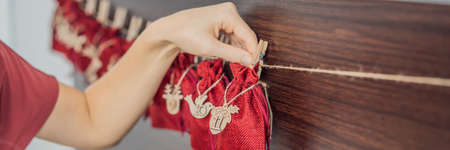 Woman making Christmas advent calendar. Pouches on a rope BANNER, LONG FORMAT