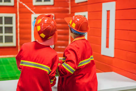 Children play firefighters, extinguish a toy fireの写真素材