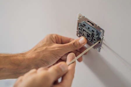 Master electrician installs a socket in the houseの写真素材