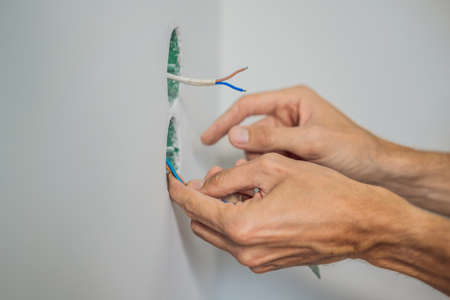 Master electrician installs a socket in the houseの写真素材