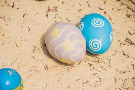 Multicolored eggs in the grass. Easter eggs hunt, outdoors. Celebrating Easter holiday