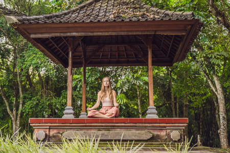 woman practicing yoga in the traditional balinesse gazeboの写真素材