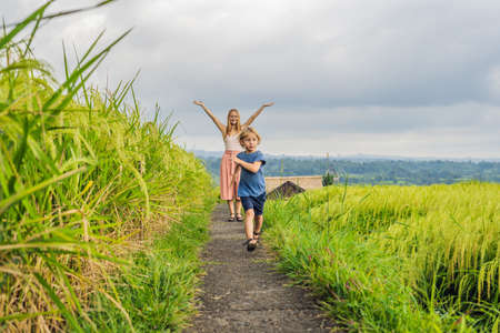 Mom and son travelers on Beautiful Jatiluwih Rice Terraces against the background of famous volcanoes in Bali, Indonesia Traveling with children conceptの写真素材