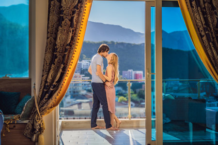 Couple on the balcony against the backdrop of mountains and city, Montenegro. life terrace pretty happiness summer home. Inspiration city romantic hotelの写真素材
