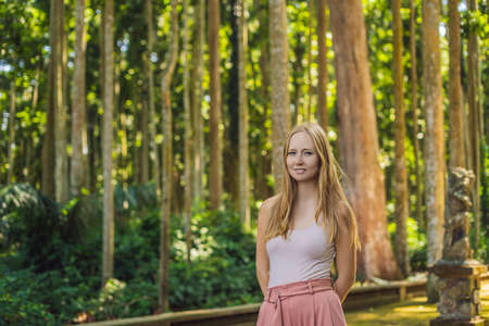 Young woman traveler discovering Ubud forest in Monkey forest, Bali Indonesia. Traveling with children conceptの写真素材
