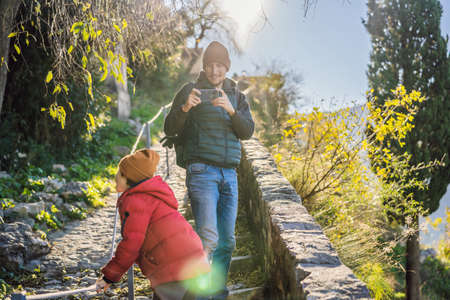 Dad and son travelers in Montenegro in Kotor Old Town Ladder of Kotor Fortress Hiking Trail. Aerial...