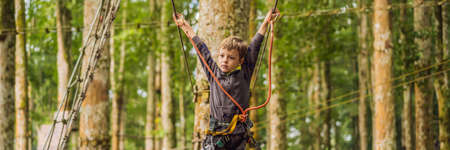 Little boy in a rope park. Active physical recreation of the child in the fresh air in the park. Training for children BANNER, LONG FORMATの写真素材