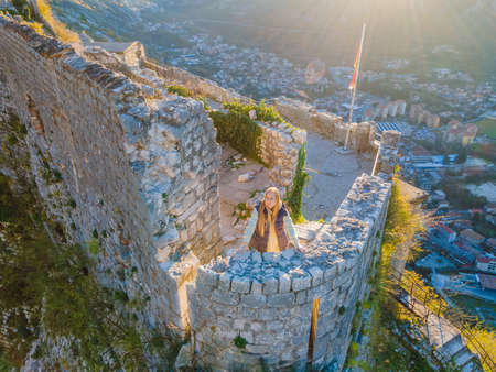 Young tourist woman enjoying a view of Kotor Bay, Montenegro. Kotor Old Town Ladder of Kotor Fortress Hiking Trail. Aerial drone viewの写真素材