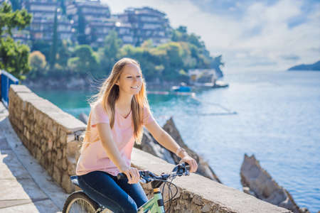 Woman tourist on a bicycle explores Budva in Montenegro. Cycling in Montenegro conceptの写真素材