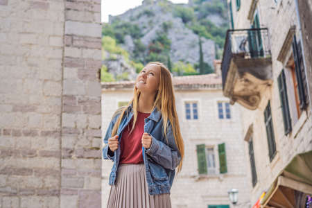 Woman tourist enjoying Colorful street in Old town of Kotor on a sunny day, Montenegro. Travel to...