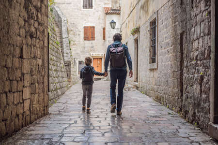 Dad and son travelers enjoying Colorful street in Old town of Kotor on a sunny day, Montenegro. Travel to Montenegro conceptの写真素材